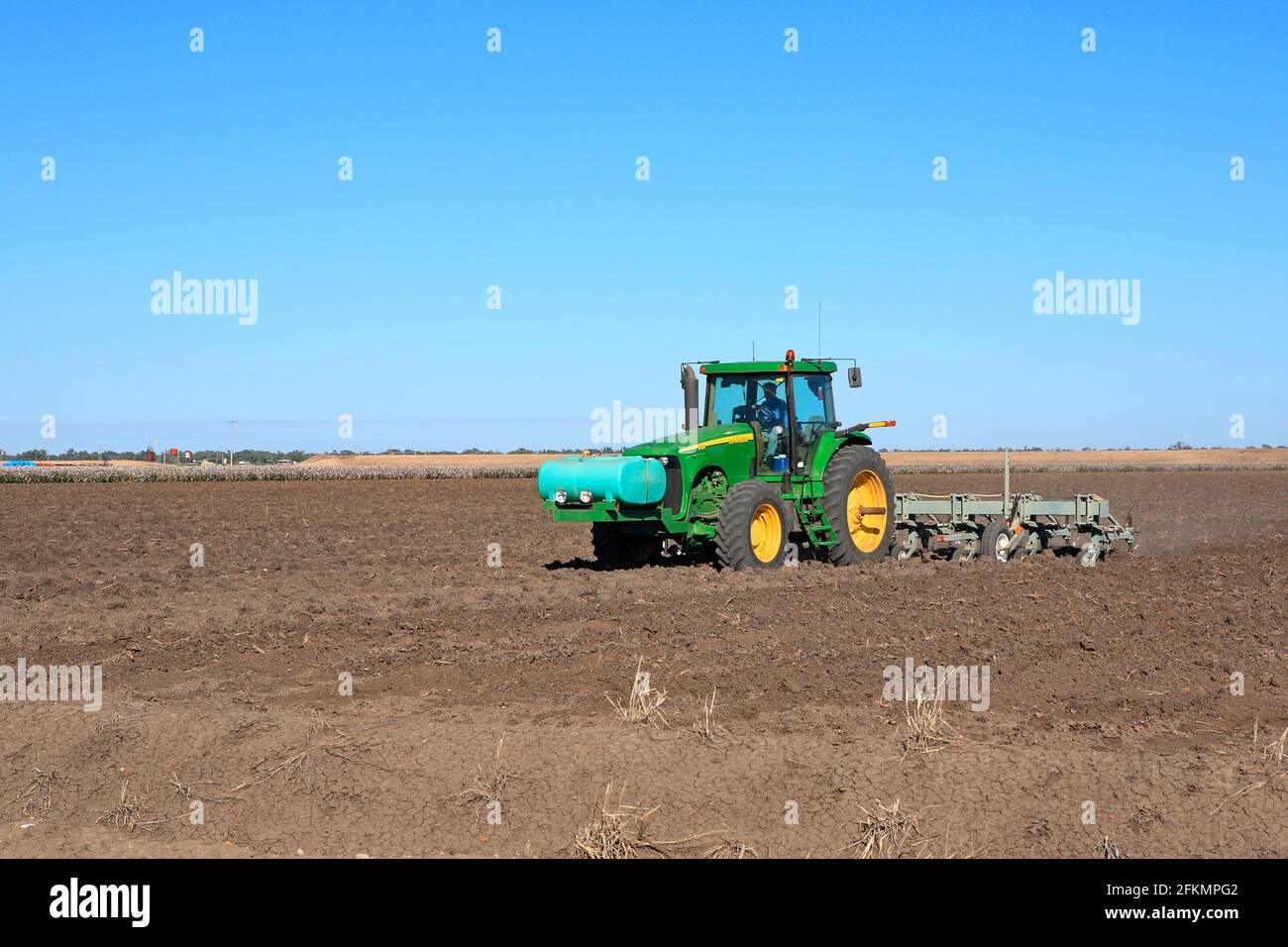 John Deere 8120 Traktor pflügt ein Baumwollfeld in der Nähe von Narrabri, NSW, Australien. An der Vorderseite des Traktors befindet sich ein Flüssigdüngertank. Stockfoto