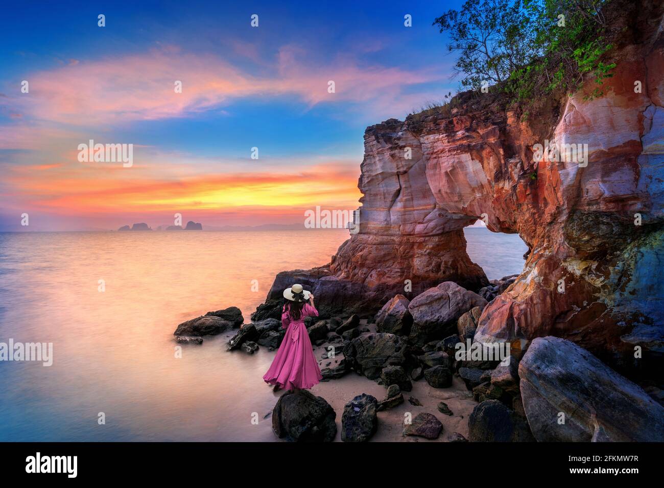 Frau, die bei Sonnenuntergang in Krabi, Thailand, auf Laem Jamuk Khwai oder Buffalo Nose Cape steht. Stockfoto