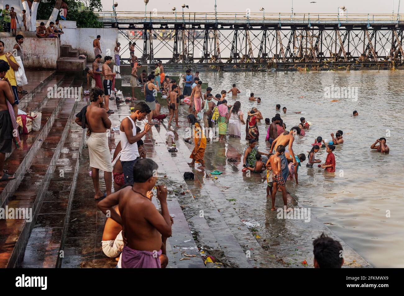 Die Menschen baden im Hoougly River (Ganges) in der Nähe der Alten Brücke, Kalkutta, Westbengala, Indien, Asien Stockfoto