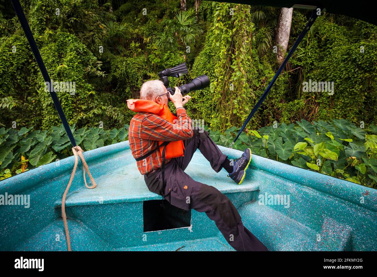 Ein Tourist mit Teleobjektiv fotografiert Wildtiere von einem Boot aus in einem der Seitenarme des Gatun Sees, Provinz Colon, Republik Panama. Stockfoto