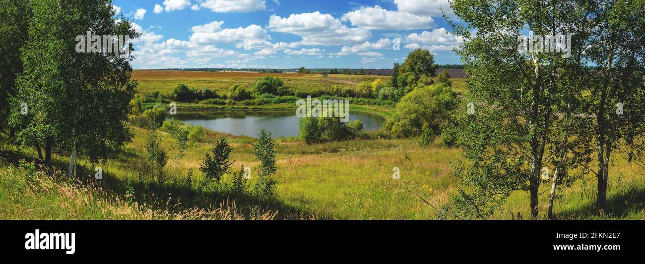 Schöne Sommer ländliche Landschaft mit See und Felder auf dem Bauernhof in sonnigen Tag.gute Sommer Panoramablick. Stockfoto