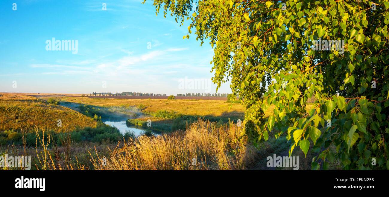 Sommermorgendszene mit ruhigen Fluss- und Bauernhöfen sonnenaufgang Stockfoto