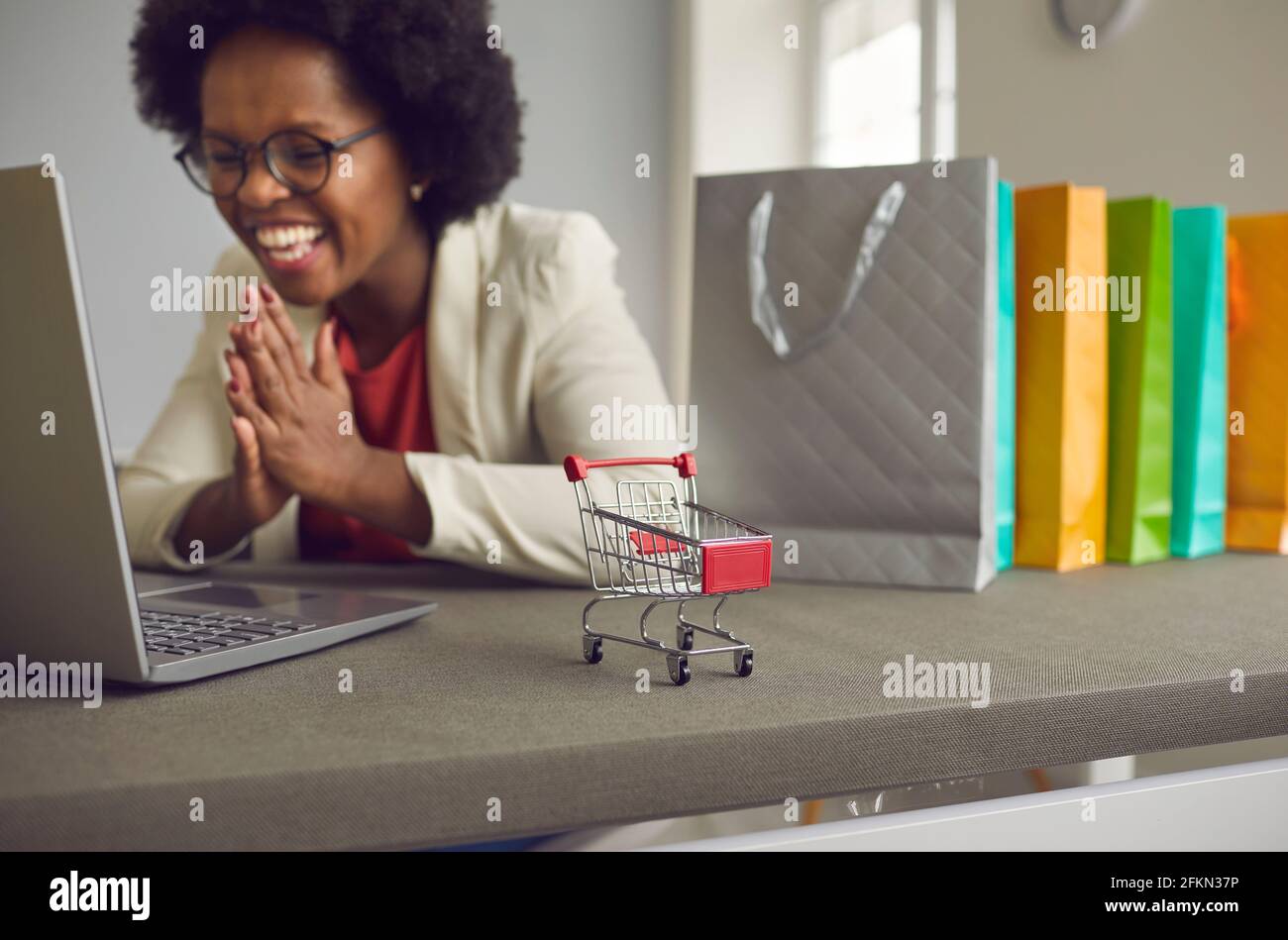 Glückliche afroamerikanische Frau, die online über Laptop kauft, freut sich über den Verkauf Angebot Stockfoto