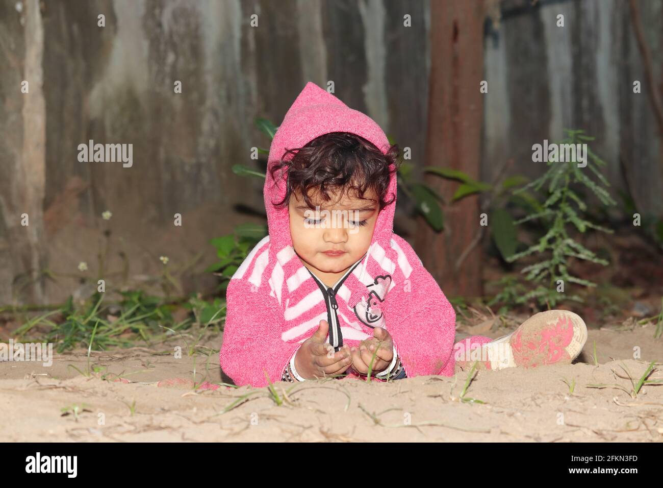 Nahaufnahme eines kleinen asiatischen Jungen, der auf sandigen Böden spielt. Konzept zur Kindheit, schönes indisches Kinderspiel, Kindheitserinnerungen. Stockfoto