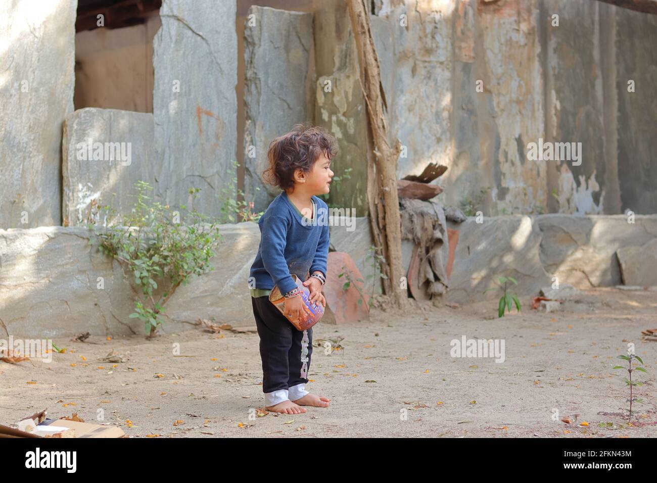 .Nahaufnahme Porträt eines asiatischen kleinen Jungen Kind spielt mit Sand und Dosen im Hof des Hauses.Konzept zur Kindheit, schöne indische Kind pla Stockfoto