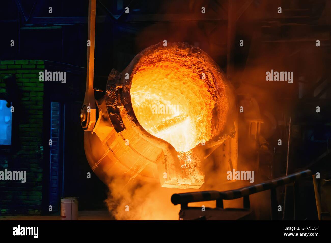 Metallgussverfahren in der Gießerei wird geschmolzenes Eisen aus der Gießpfanne in den Hochofen gegossen. Stockfoto