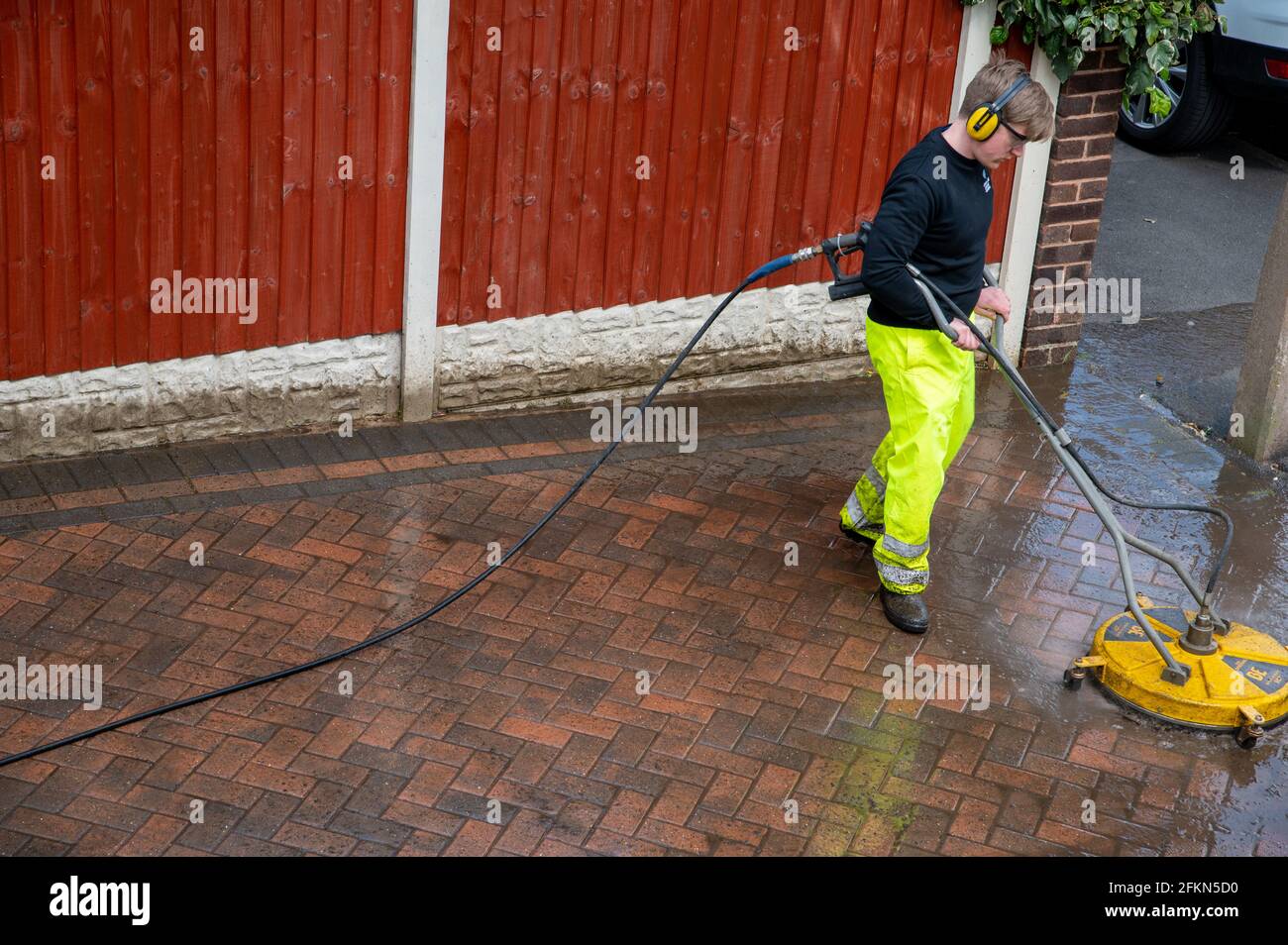 Auftragnehmer Reinigung inländischen Block gepflasterten Auffahrt mit Hochdruckwasser Stockfoto