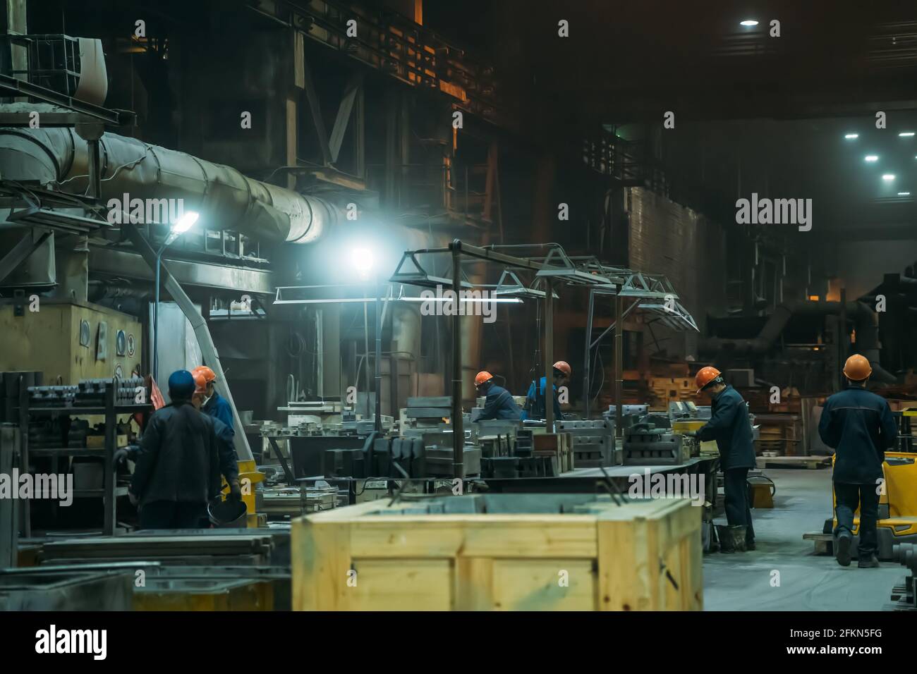 Stahlfabrik mit Arbeitern im Prozess der Arbeit, industrielle Innenausstattung, großer Hangar mit Eisenproduktion. Stockfoto