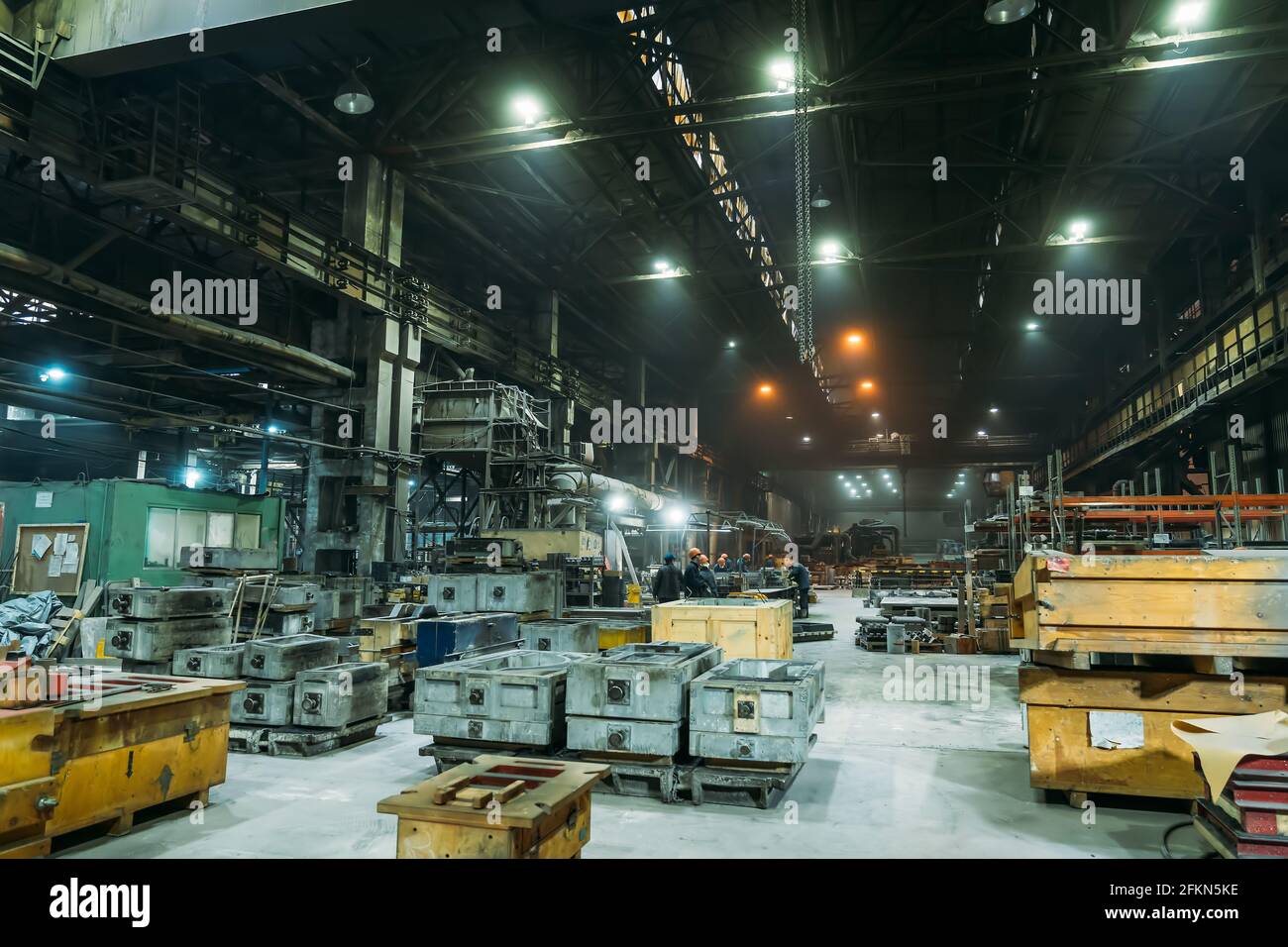 Stahlfabrik mit Arbeitern im Prozess der Arbeit, industrielle Innenausstattung, großer Hangar mit Eisenproduktion. Stockfoto