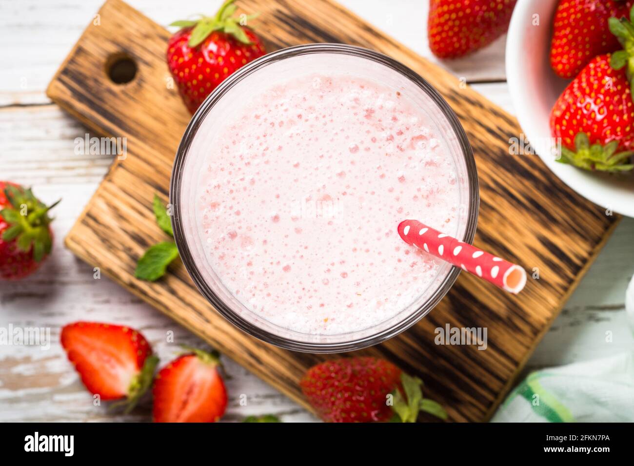 Erdbeer-Smoothie oder Milchshake am weißen Tisch. Stockfoto