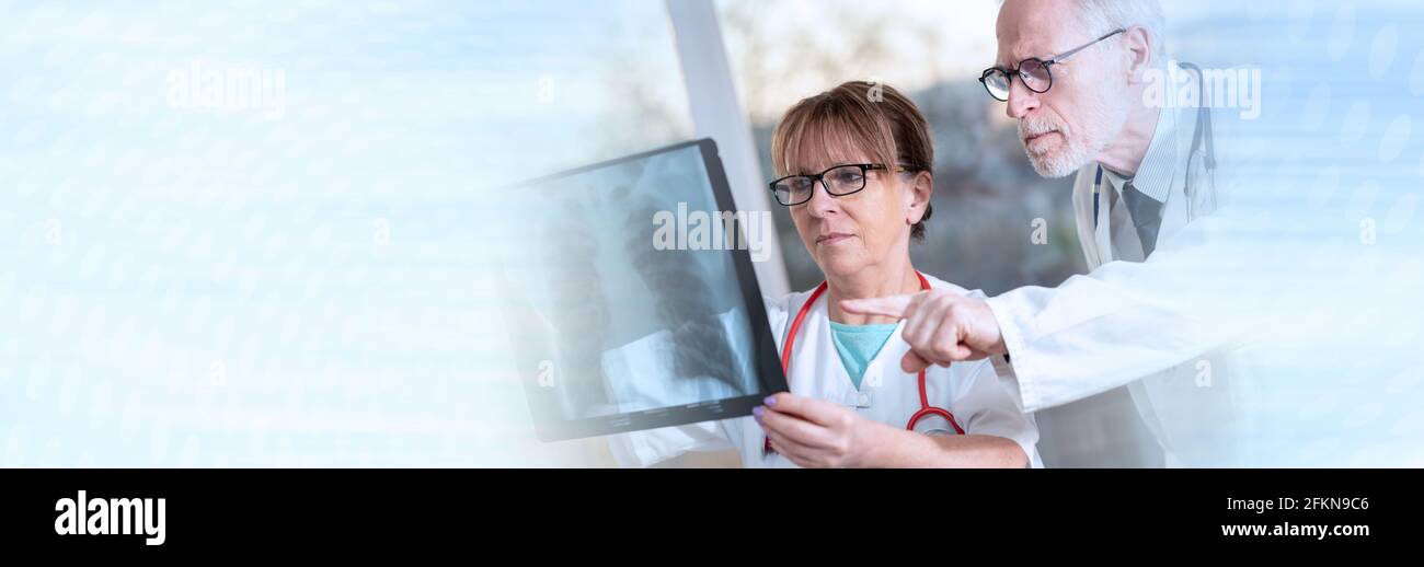 Zwei Ärzte untersuchen Röntgenbericht in der Arztpraxis; Panorama-Banner Stockfoto
