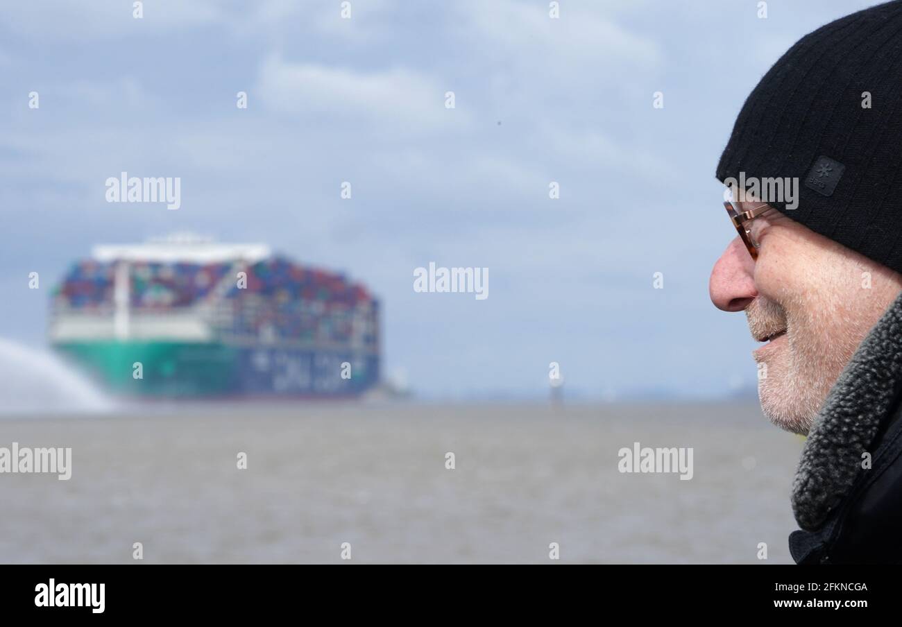 Hamburg, Deutschland. Mai 2021. Michael Westhagemann (non-Party), Senator für Wirtschaft und Innovation in Hamburg, steht am Teufelsbrück-Steg an der Elbe, als das Containerschiff 'CMA CGM Jacques Saade' der Reederei CMA CGM in Richtung Hafen fährt. Große Containerschiffe können den Hamburger Hafen mit einem um bis zu 0.9 Meter erhöhten Tiefgang bedienen. Nach fast zwei Jahren Bauzeit kann die Schifffahrt die neuen Fairwaytiefen der Elbe nutzen. Kredit: Marcus Brandt/dpa/Alamy Live Nachrichten Stockfoto