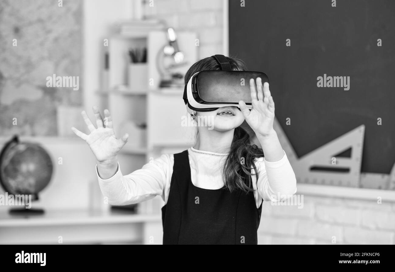 Schulkind mit Virtual Reality. Virtual Reality Headset. Teenager-Schulmädchen im Klassenzimmer. Zurück zur Schule. In einem Informatikkurs. Funktioniert auf einem Stockfoto