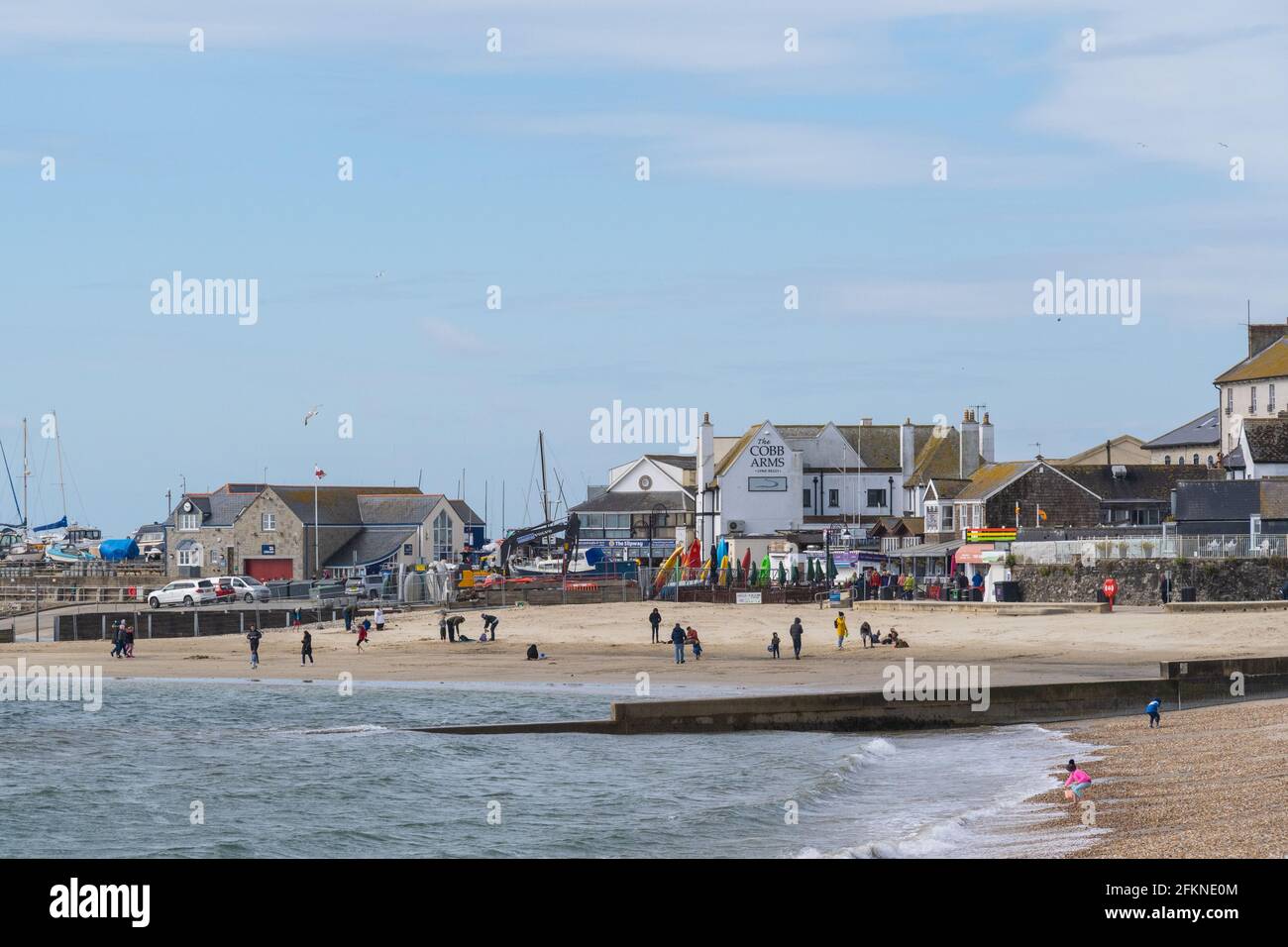 Lyme Regis, Dorset, Großbritannien. Mai 2021. Wetter in Großbritannien. Ein stürziger Start in den Feiertag Montag am Badeort Lyme Regis. Ein paar Leute waren entschlossen, den letzten Sonnenzauber am Strand zu genießen, bevor die stürmischen Bedingungen für den Nachmittag prognostiziert wurden. Kredit: Celia McMahon/Alamy Live Nachrichten Stockfoto