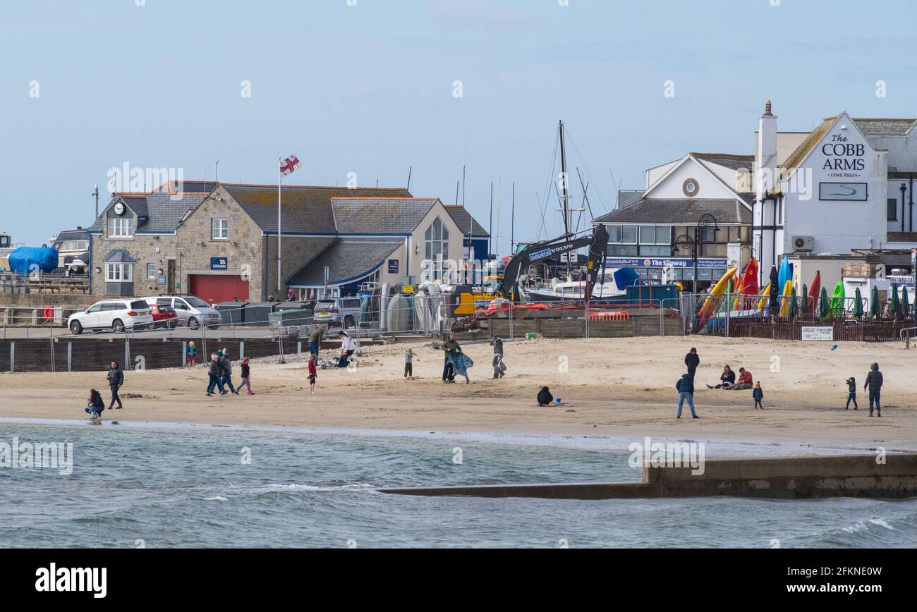 Lyme Regis, Dorset, Großbritannien. Mai 2021. Wetter in Großbritannien. Ein stürziger Start in den Feiertag Montag am Badeort Lyme Regis. Ein paar Leute waren entschlossen, den letzten Sonnenzauber am Strand zu genießen, bevor die stürmischen Bedingungen für den Nachmittag prognostiziert wurden. Kredit: Celia McMahon/Alamy Live Nachrichten Stockfoto