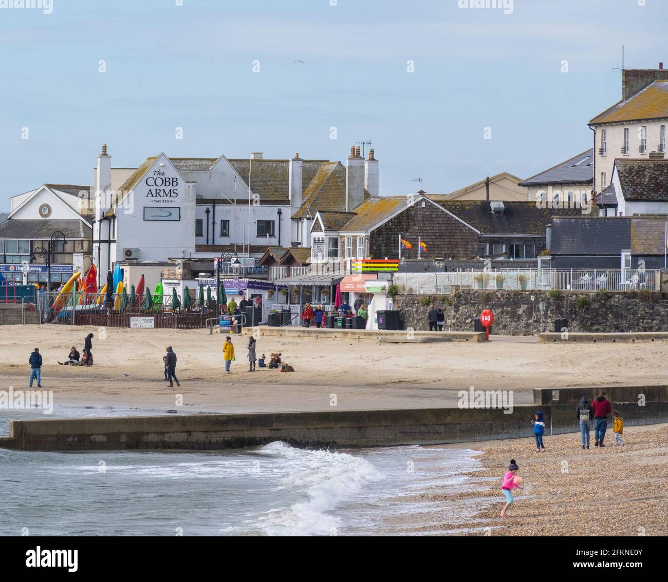 Lyme Regis, Dorset, Großbritannien. Mai 2021. Wetter in Großbritannien. Ein stürziger Start in den Feiertag Montag am Badeort Lyme Regis. Ein paar Leute waren entschlossen, den letzten Sonnenzauber am Strand zu genießen, bevor die stürmischen Bedingungen für den Nachmittag prognostiziert wurden. Kredit: Celia McMahon/Alamy Live Nachrichten Stockfoto