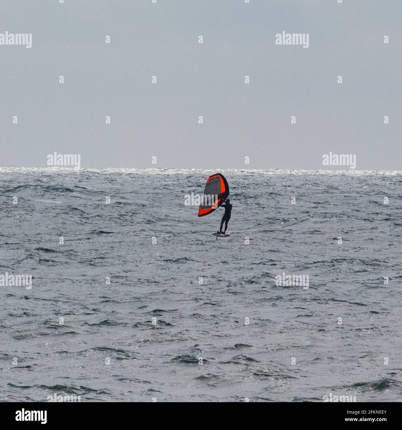Lyme Regis, Dorset, Großbritannien. Mai 2021. Wetter in Großbritannien. Ein stürziger Start in den Feiertag Montag am Badeort Lyme Regis. Ein paar Leute waren entschlossen, den letzten Sonnenzauber am Strand zu genießen, bevor die stürmischen Bedingungen für den Nachmittag prognostiziert wurden. Kredit: Celia McMahon/Alamy Live Nachrichten Stockfoto