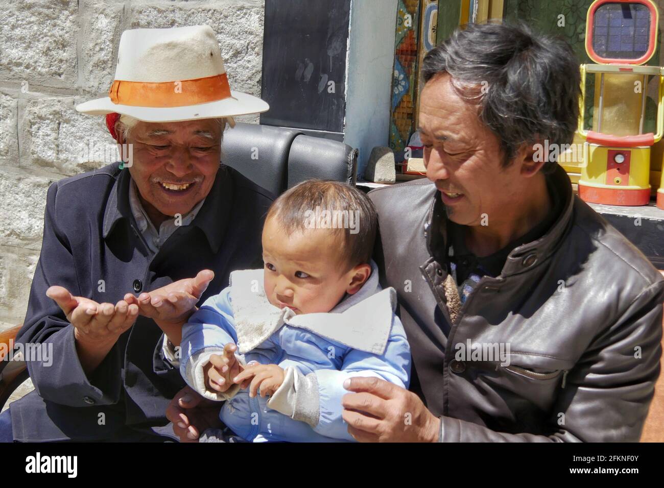 (210503) -- LHASA, 3. Mai 2021 (Xinhua) -- Dondrup Wangyal (1. L) interagiert mit seinem Urenkel in der Gemeinde Gangdoi, Bezirk Gonggar der Stadt Shannan, südwestlich der Autonomen Region Tibet, 5. April 2021. Dondrup Wangyal, 79, wurde als Sohn einer Leibeigenfamilie in der Gemeinde Gangdoi geboren. Seit Generationen war Dondrup Wangyals Familie Leibeigene einer lokalen lord-Familie bis zur demokratischen Reform im Jahr 1959, als er wirklich emanzipiert und mit Ackerland betraut wurde. Ich war damals nur 17 Jahre alt, aber ich würde nie vergessen, dass die Kommunistische Partei Chinas mich gerettet hat. Und ich entschlossene sich, ein Parteimitglied zu werden Stockfoto