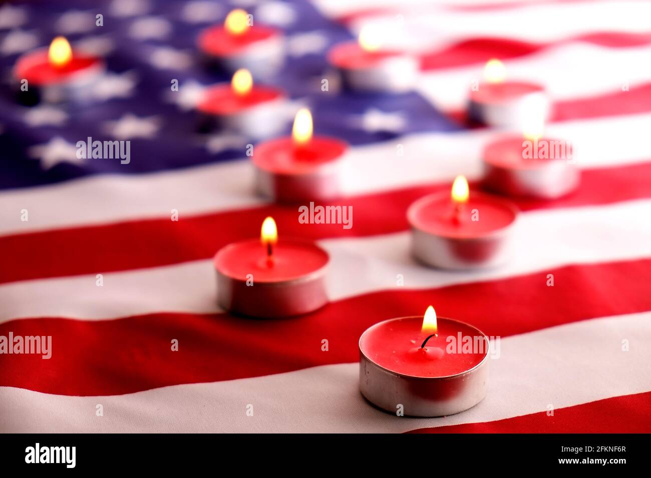 Trauerkerzen brennen auf US-amerikanischer Nationalflagge Hintergrund. Memorial Weekend, Patriot Veterans Day, 9/11 National Day of Service & Remembrance. Stockfoto