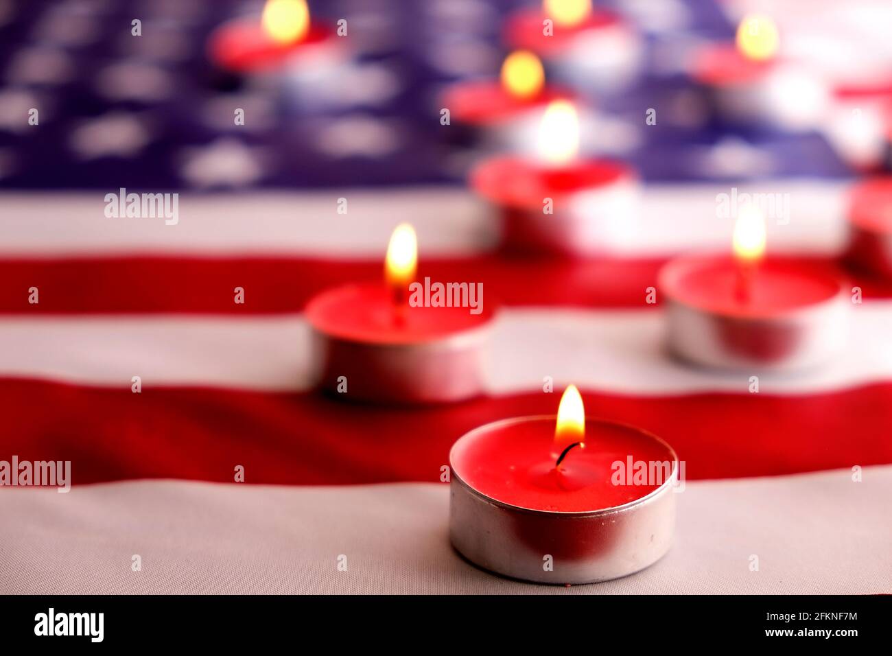 Trauerkerzen brennen auf US-amerikanischer Nationalflagge Hintergrund. Memorial Weekend, Patriot Veterans Day, 9/11 National Day of Service & Remembrance. Stockfoto