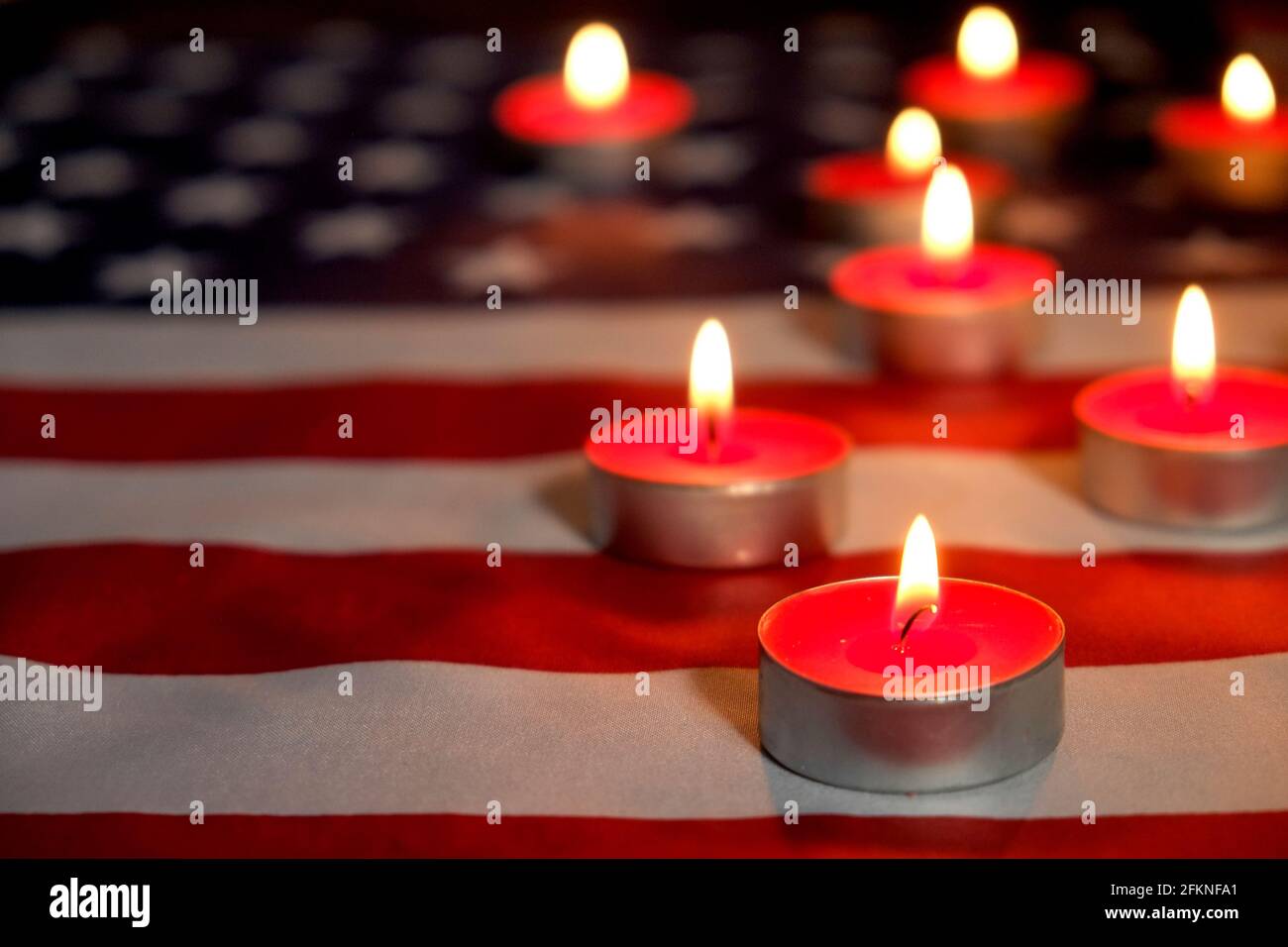 Trauerkerzen brennen auf US-amerikanischer Nationalflagge Hintergrund. Memorial Weekend, Patriot Veterans Day, 9/11 National Day of Service & Remembrance. Stockfoto