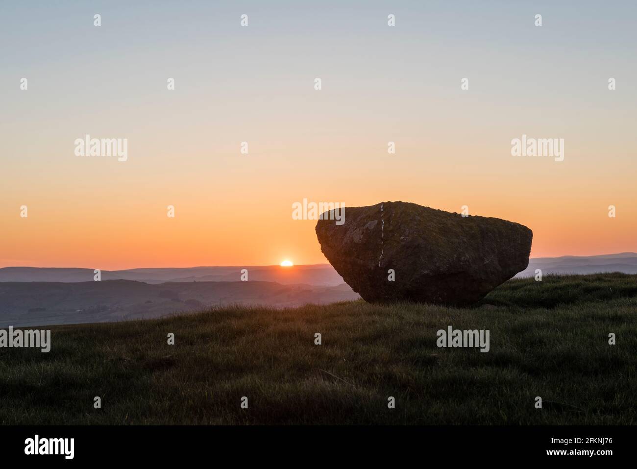 Der gefallene bronzezeitliche stehende Stein von Bryn-y-Maen, in der Nähe von Llandegley in der Mitte von Wales, Großbritannien, bei Sonnenuntergang gesehen Stockfoto