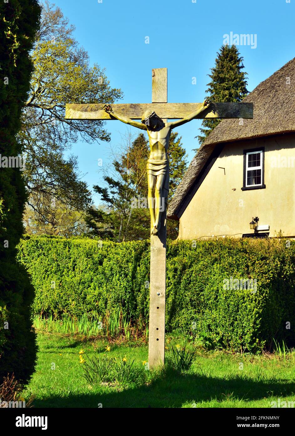 Kruzifix beim Ferienhaus in Furzey Gardens, Minstead, Hampshire. Das Reethaus inmitten der Gärten war ursprünglich ein christlicher Rückzugsort Stockfoto