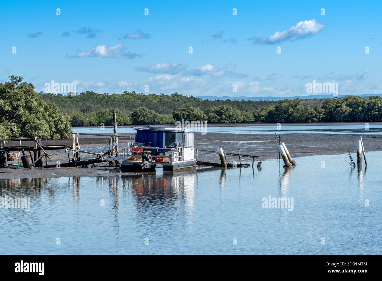 Ein Boot an einem Dock in der Pumicestone Passage, in der Nähe von Brisbane, Queensland, Australien Stockfoto
