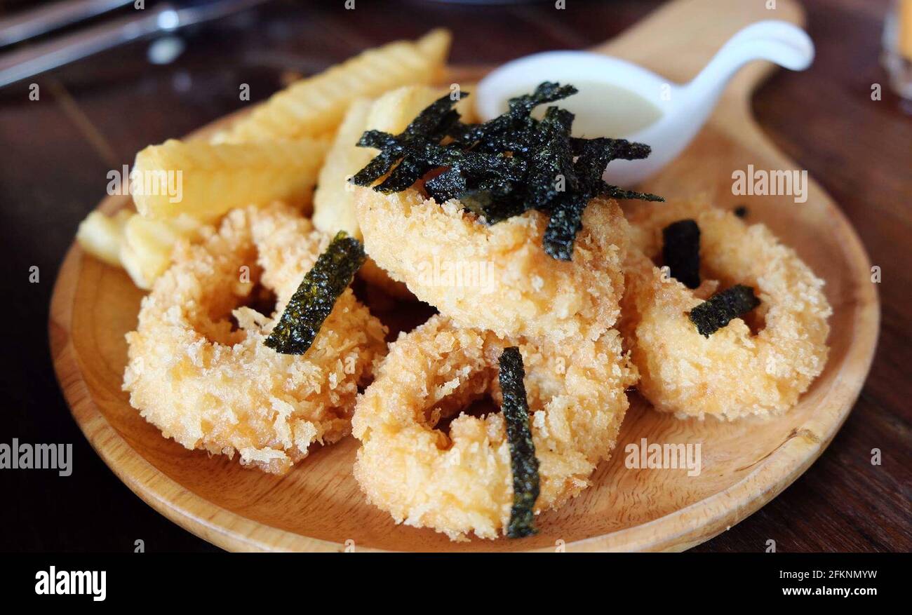 Frittierte Tintenfischringe auf Holzplatte Stockfoto