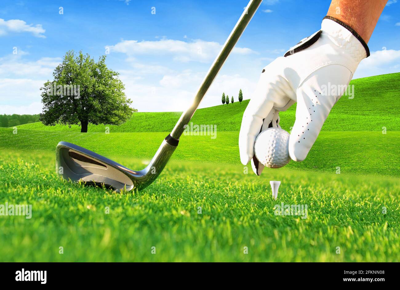 Golfspieler-Hand, die einen Golfball auf Abschlag im Golf setzt Kurs Stockfoto