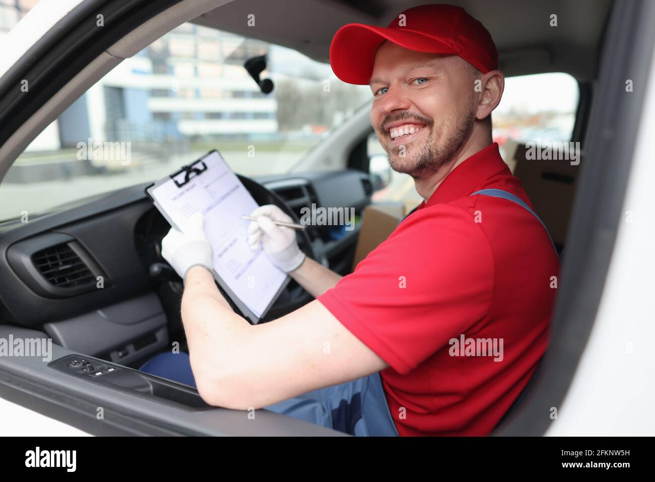 Kurier Mann Ausfüllen von Dokumenten auf Zwischenablage im Auto Stockfoto