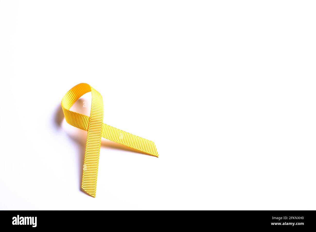 Gelbes Band - Symbol für das Bewusstsein für Blase, Leber und Knochenkrebs. Kinderkrebsprävention Assoziationskonzept. Isolierter Hintergrund, Kopierbereich, clos Stockfoto