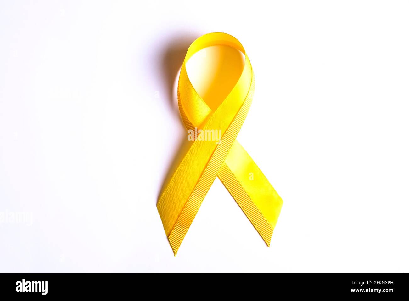 Gelbes Band - Symbol für das Bewusstsein für Blase, Leber und Knochenkrebs. Kinderkrebsprävention Assoziationskonzept. Isolierter Hintergrund, Kopierbereich, clos Stockfoto