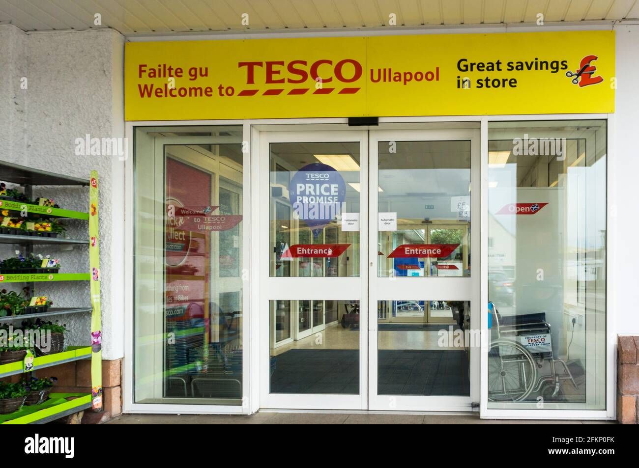 Biligual English & Scottish Gälisch Willkommensschild über dem Eingang zum Tesco Supermarkt in Ullapool, Highlands of Scotland. Stockfoto