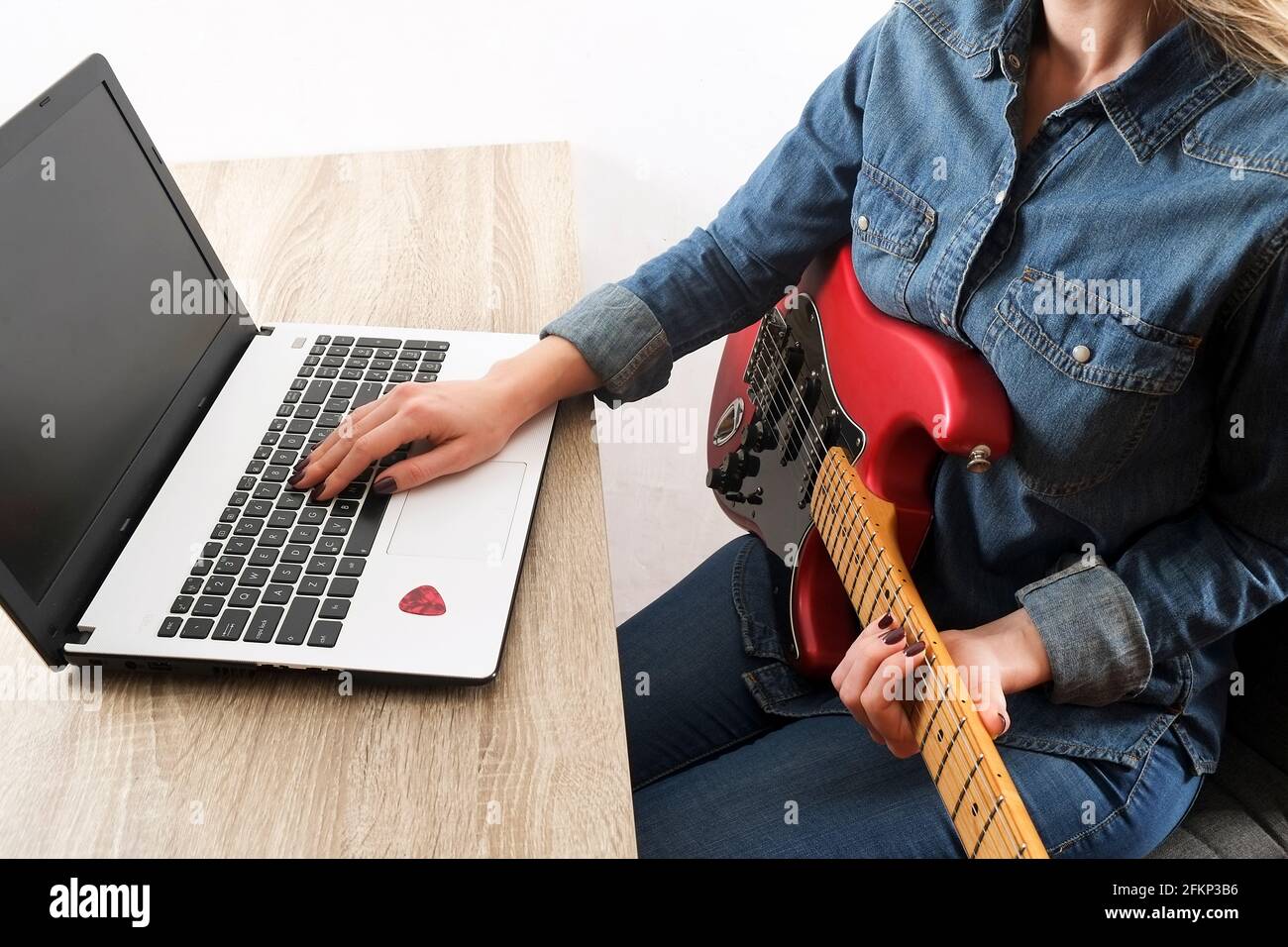 Weibliche Hipster Musik College-Student üben E-Gitarre Übung, Lesen von Notizen, pc-Laptop-Computer. Frau lehrt sich selbst, nimmt Musical an Stockfoto