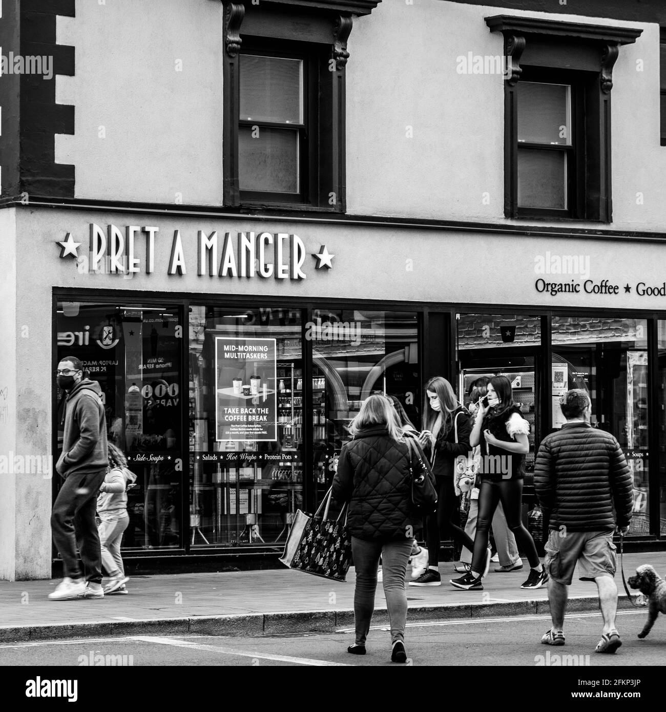 Epsom Surrey London, Großbritannien, Mai 02 2021, Gruppe von Menschen oder Einkäufern, die die Straße in Richtung EINES Pret A Manger Coffee Shop überqueren Stockfoto