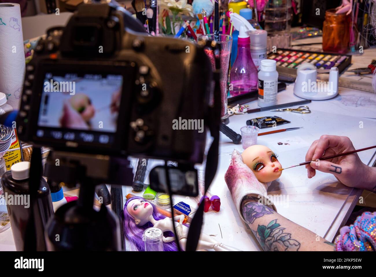 Strasburg, Deutschland. April 2021. Die Modedesignerin Elisa lange malt die  Manga-Puppe 'Lylla', die sie in der Werkstatt entworfen hat. Die 32-Jährige  sendet ihre Arbeit im Internet und beliefert heute Kunden auf der