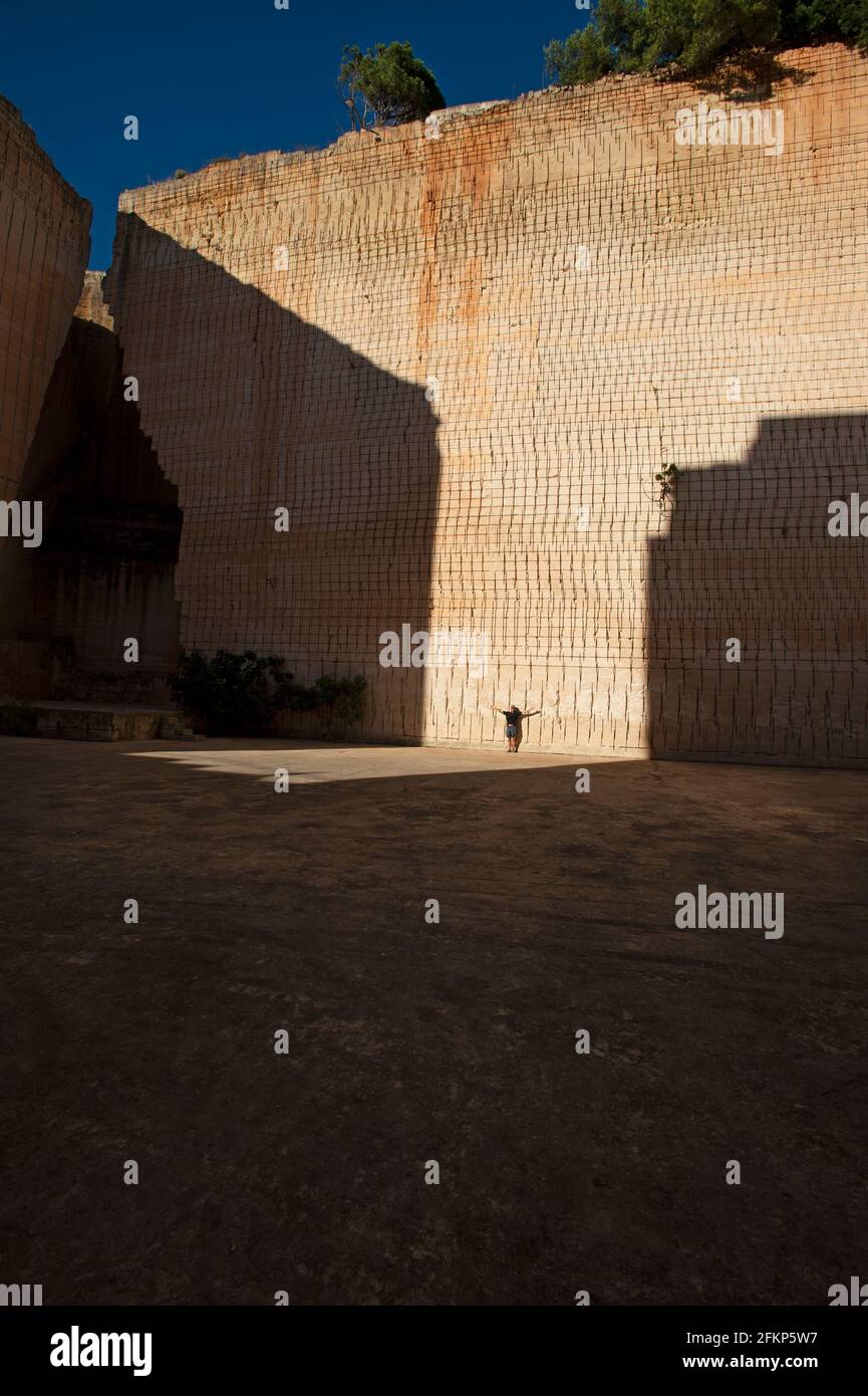 Ein Mann gibt dem riesigen Kalksteinbruch Lithica Kalkablagerungen De s'Hostal etwas außerhalb von ciutadella menorca Stockfoto