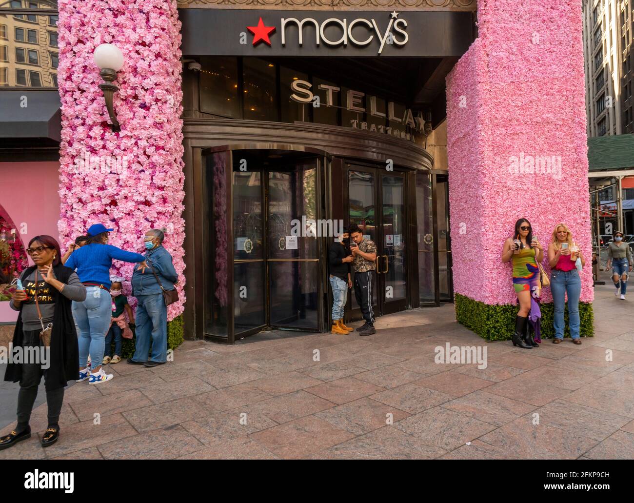 Besucher vor Macy's Flagship-Kaufhaus am Herald Square in New York, das mit Blumenarrangements für die jährliche Macy's Flower Show am Eröffnungstag Sonntag, den 2. April 2021, behauen ist. Besucher strömen zur diesjährigen Show mit dem diesjährigen Thema, Give. Liebe. Bloom.“ Die Show, die letztes Jahr aufgrund der Pandemie auf Pause war, wurde entwickelt, um soziale Distanzierungen zu fördern. Die Show läuft bis zum 16. Mai. (Foto von Richard B. Levine) Stockfoto