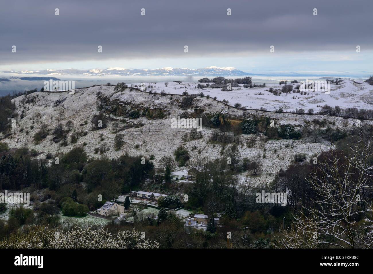 Birdlip, Cotwolds, Gloucestershire, Großbritannien mit Schnee im April mit Malvern Hills in der Ferne. Blick über das Avon Valley. Stockfoto