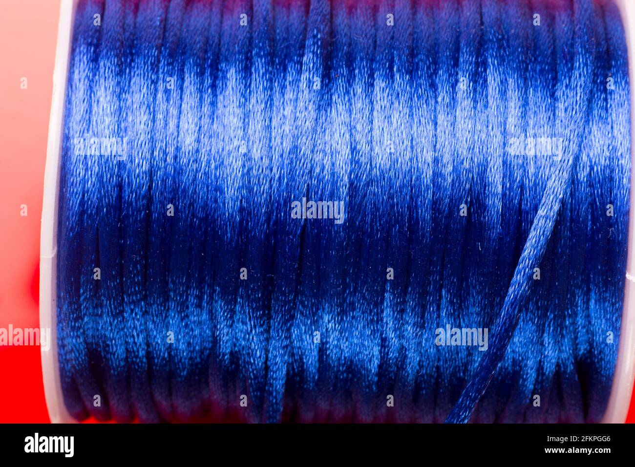 Spule aus blauem Garn, Garn zum Verzieren von Geschenken und zum Herstellen kleiner Knoten. Stockfoto