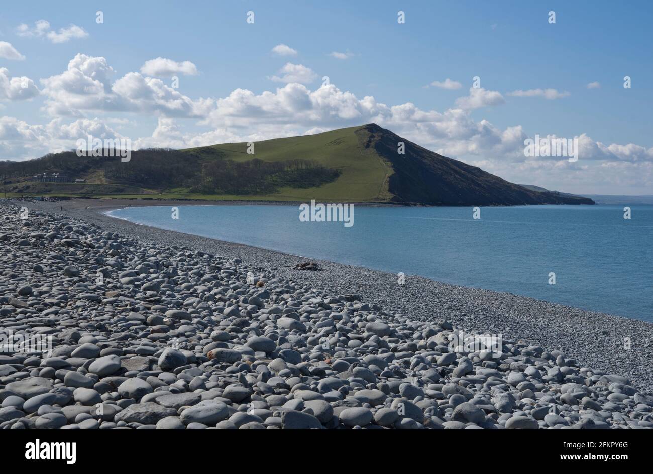 Strand mit Kieselsteinen, Felsen und gestapelten Kalksteinschichten in Ceredigion, Wales, UK Stockfoto