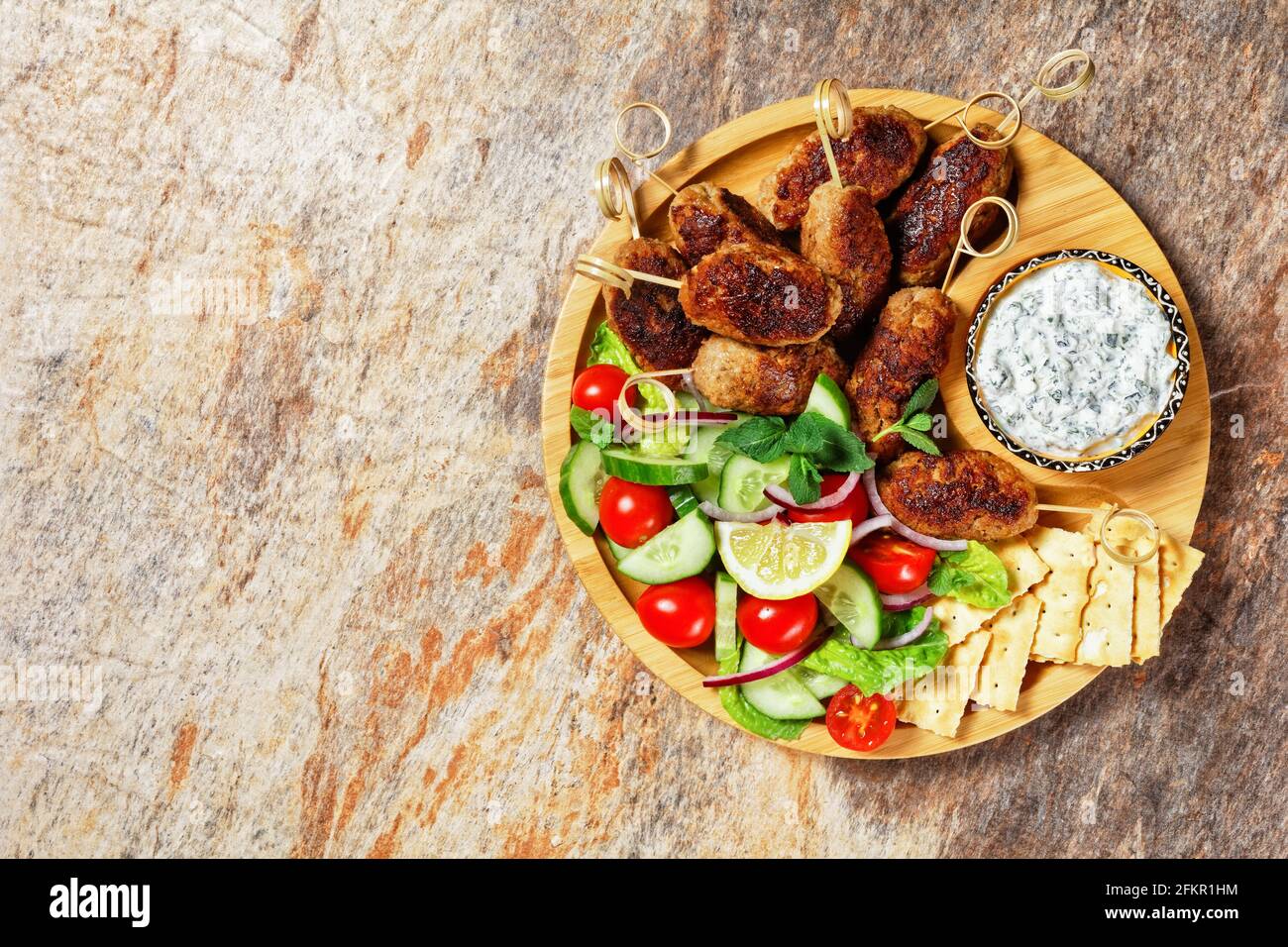 Griechische Lamm- und Feta-Kofta-Spieße mit frischen Tomaten, Minze ... Griechische Lamm- und Feta-Kofta-Spieße mit frischen Tomaten, Minze ...