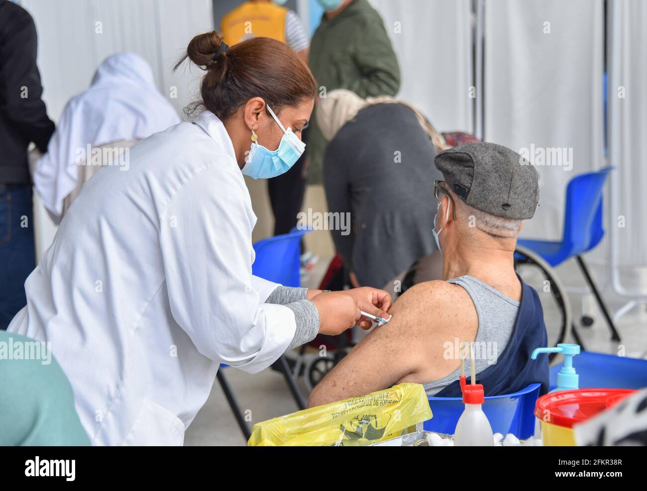 Tunis, Tunesien. Mai 2021. Ein älterer Mann erhält eine Dosis des Pfizer-BioNTech COVID-19-Coronavirus-Impfstoffs, während andere in der Sporthalle El-Menzah in der tunesischen Hauptstadt auf ihren Zug warten. Kredit: SOPA Images Limited/Alamy Live Nachrichten Stockfoto