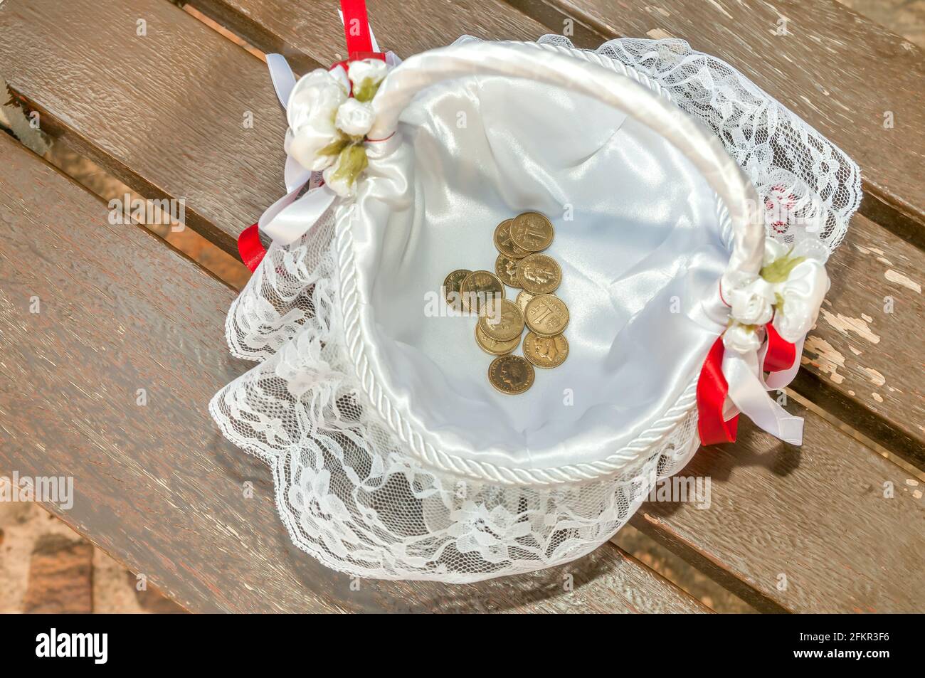 Arras, Münzen, die symbolisch in einer Hochzeitszeremonie verwendet werden, die in einem Korb, Pesetas, platziert wird. Stockfoto