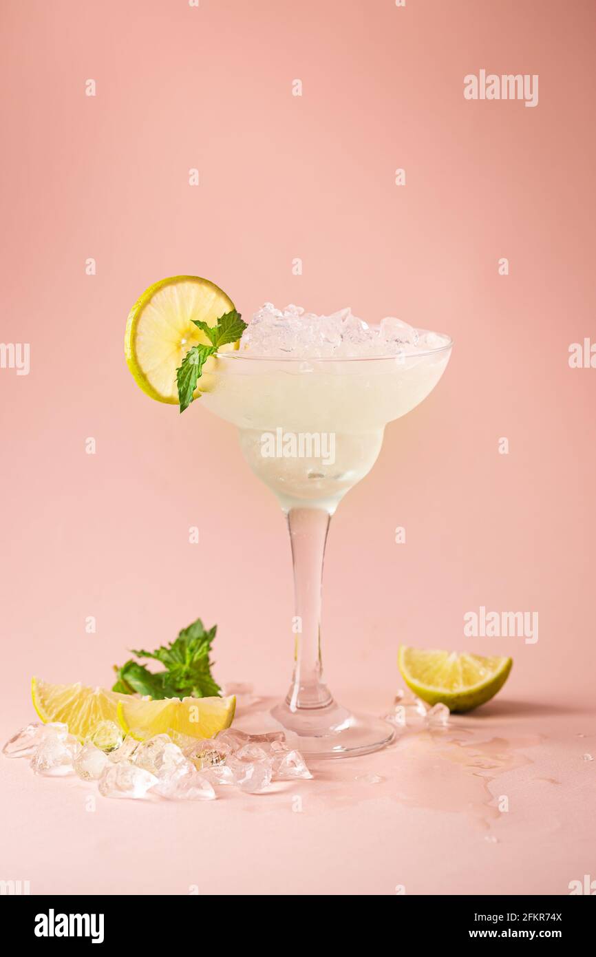 Cocktail margarita garniert mit Limette und Minze auf rosa Hintergrund Stockfoto