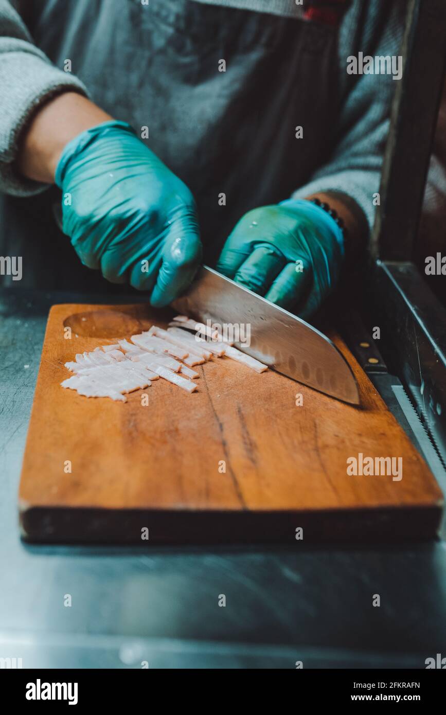 Person, die das Fleisch für die Herstellung von Burgern schneidet Stockfoto