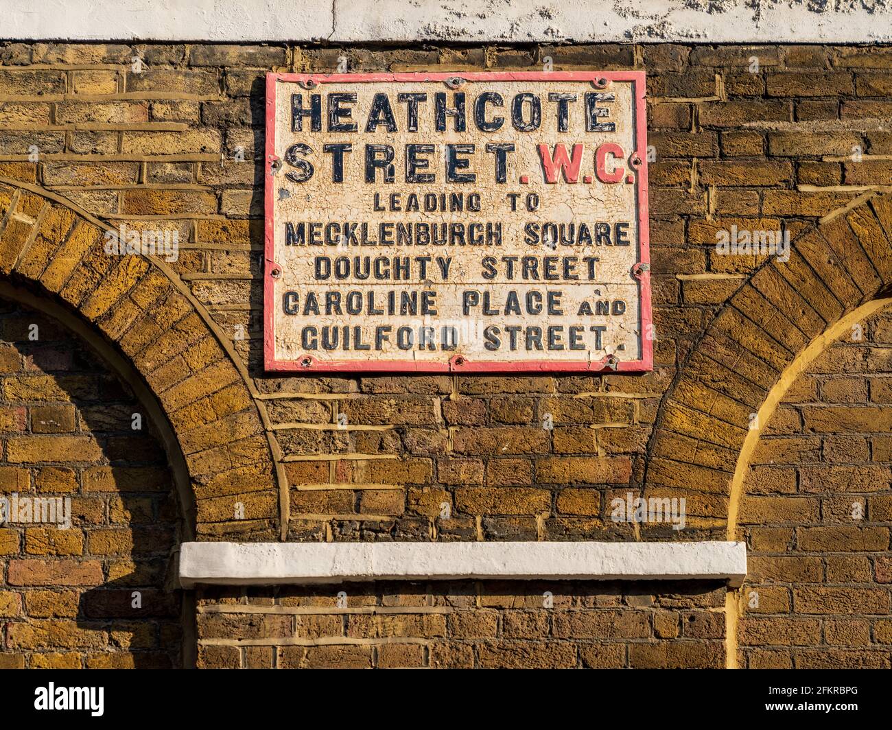 Heathcote Street WC London Street Sign - Vintage London Street Sign in Richtung Heathcote Street, die zum Meckenburgh Square, Doughty St, Caroline Place führt. Stockfoto