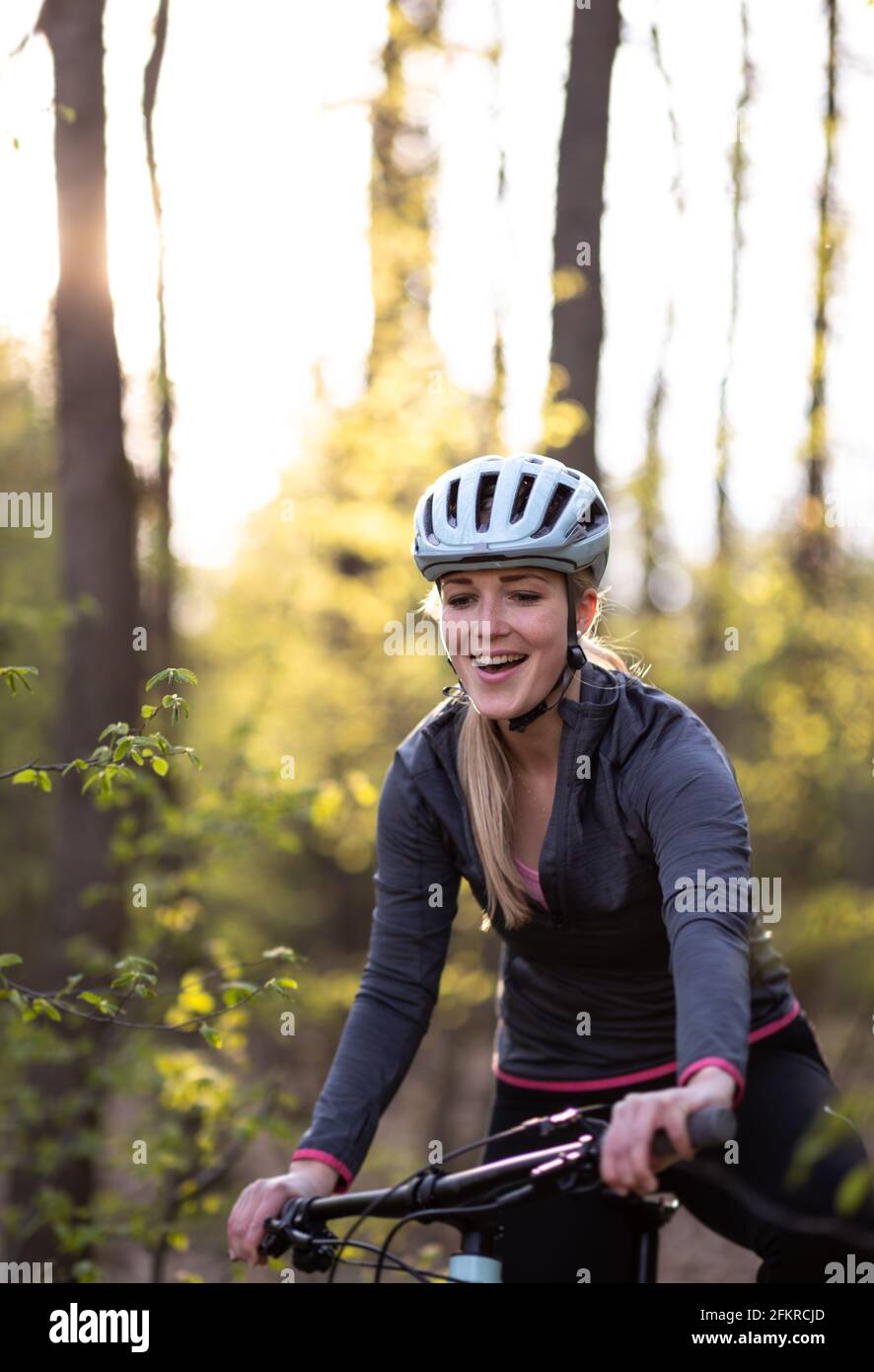 Hübsche, junge Frau mit ihrem Mountainbike, die die Stadtgrenzen überschreitet und ihre tägliche Dosis Cardio erhält Stockfoto