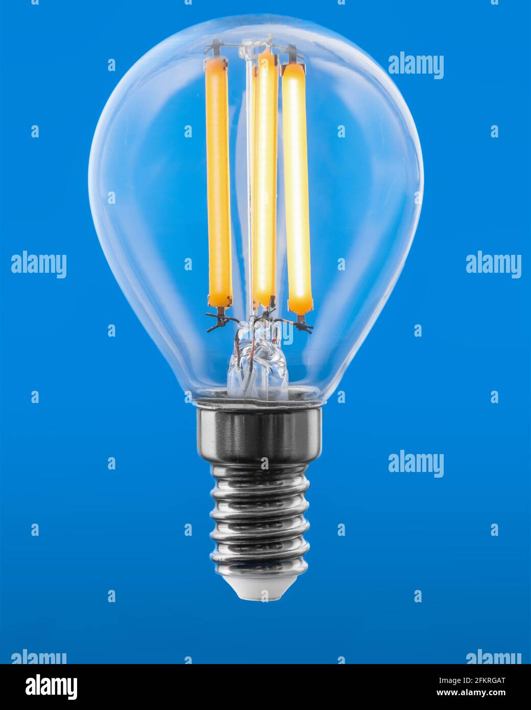 Energieeffiziente LED-Glühlampe Glühlampe leuchtet isoliert auf blauem Hintergrund. Stockfoto